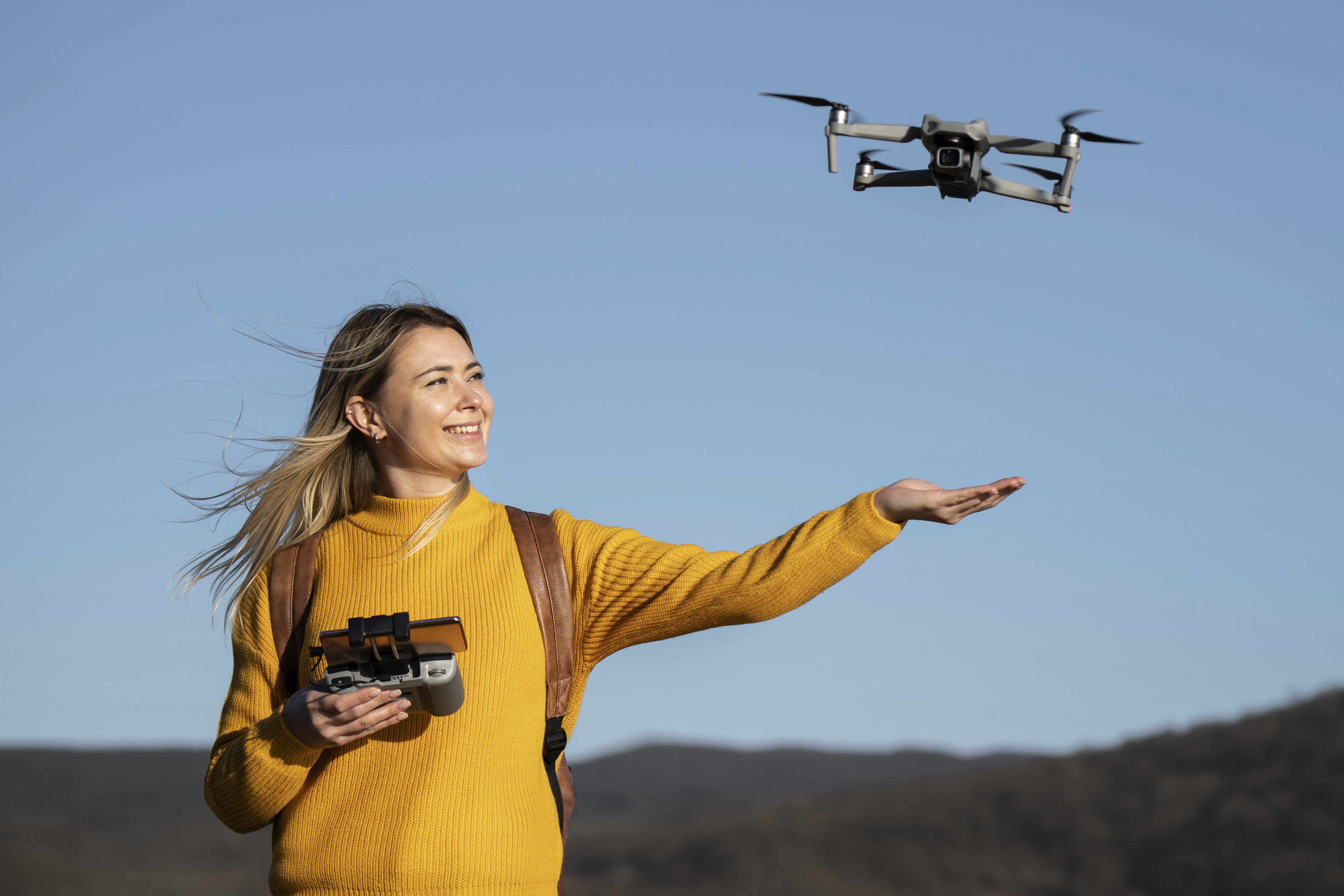 mujer-sonriente-de-tiro-medio-con-drone-afuera